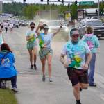 Participants are covered with colored powder during a color run held as part of during the Levitt AMP Soldotna Music Series on Wednesday, June 7, 2023, along the Sterling Highway in Soldotna, Alaska. (Jake Dye/Peninsula Clarion)