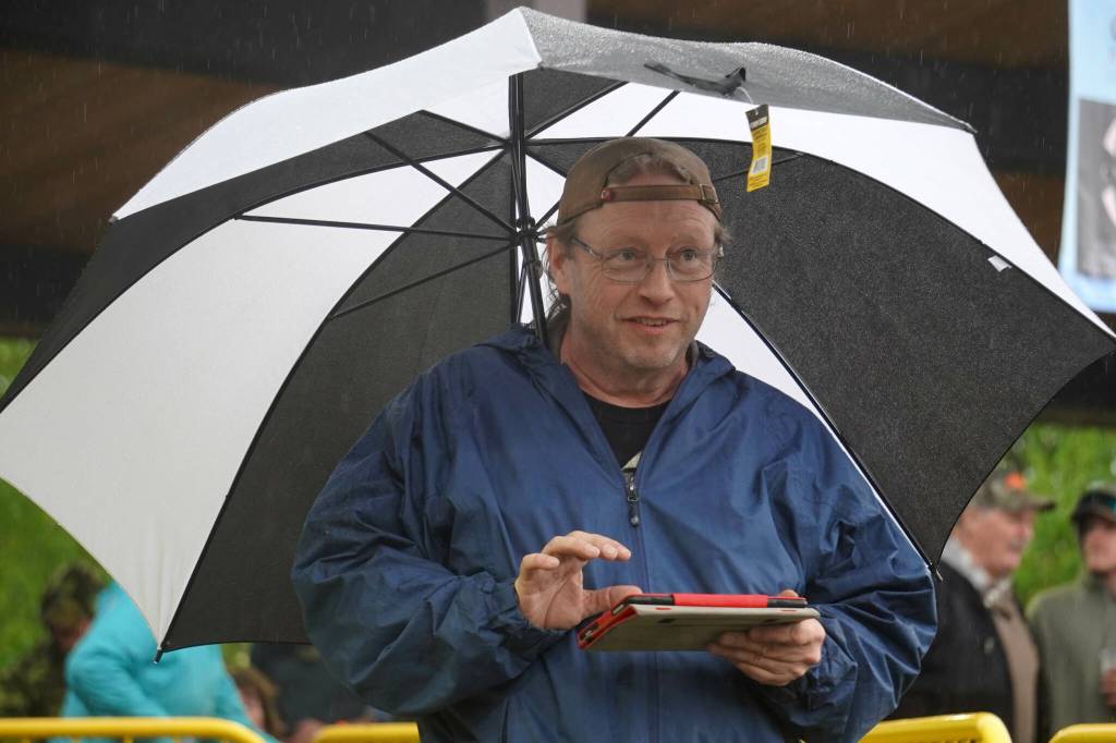 Paul Wright, of Bassline Sound, mixes audio for Hope Social Club under rainfall during the opening night of the 2024 Levitt AMP Soldotna Music Series at Soldotna Creek Park in Soldotna, Alaska, on Wednesday, June 5, 2024. (Jake Dye/Peninsula Clarion)