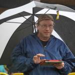 Paul Wright, of Bassline Sound, mixes audio for Hope Social Club under rainfall during the opening night of the 2024 Levitt AMP Soldotna Music Series at Soldotna Creek Park in Soldotna, Alaska, on Wednesday, June 5, 2024. (Jake Dye/Peninsula Clarion)