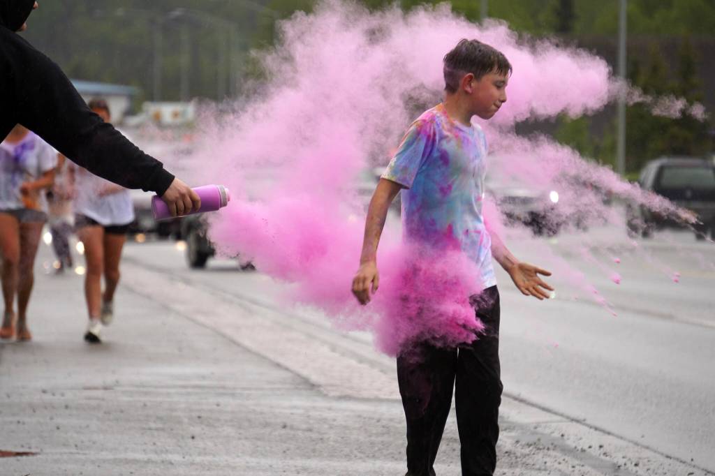 Attendees brave purple colored powder during a color run as part of the opening night of the Levitt AMP Soldotna Music Series along the Sterling Highway in Soldotna, Alaska, on Wednesday, June 5, 2024. (Jake Dye/Peninsula Clarion)