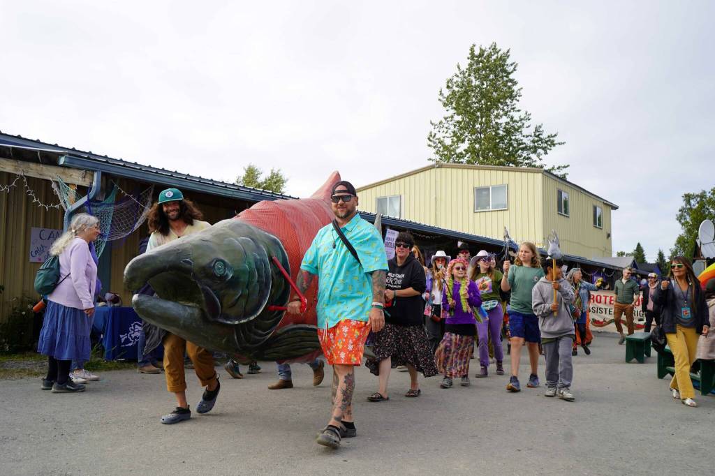 People parade through the Salmon Causeway at Salmonfest in Ninilchik, Alaska, on Saturday, Aug. 3, 2024. (Jake Dye/Peninsula Clarion)
