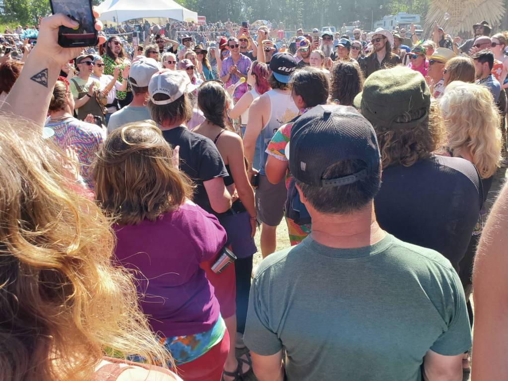 Concertgoers gather around Glitterfox lead singer, Solange Igoa, after she descended the stage into the crowd during the bands Salmonfest performance on Sunday, Aug. 4, 2024, at the Kenai Peninsula Fairgrounds in Ninilchik, Alaska. (Delcenia Cosman/Homer News)