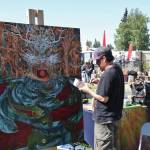 Anchorage-based artist Adam Shea paints live at Salmonfest next to the River Stage Amphitheater on Sunday, Aug. 4, 2024, in Ninilchik, Alaska. (Delcenia Cosman/Homer News)