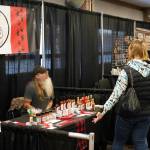 Terry Holmes, of Bear Spray Hot Sauce, chats with shoppers at the 33rd Annual Holiday Bazaar at the Soldotna Regional Sports Complex in Soldotna, Alaska, on Friday, Nov. 22, 2024. (Jonas Oyoumick/Peninsula Clarion)