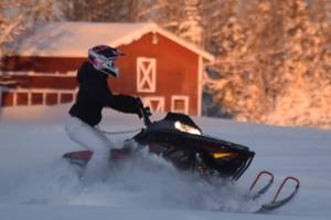 A snowmachine rider takes advantage of 2 feet of fresh snow on a field down Murwood Avenue in Soldotna, Alaska, on Monday, Dec. 12, 2022. (Jake Dye/Peninsula Clarion)