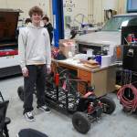 Gavin Ley stands with the Go-Shopping Kart he designed and built in his career and technical education courses at Nikiski Middle/High School in Nikiski, Alaska, on Tuesday, Feb. 11, 2025. (Jake Dye/Peninsula Clarion)