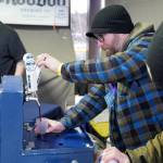 A brewer from Kenai River Brewing Company fills a cup for an attendee at the 10th Annual Frozen River Fest in Soldotna, Alaska, on Saturday, Feb. 15, 2025. (Jake Dye/Peninsula Clarion)