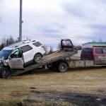 A 2015 Ford Explorer that police say was stolen from the Kenai Chamber of Commerce and Visitor Center before crashing into a tree near Wells Fargo Bank is loaded onto a tow truck in Kenai, Alaska, on Tuesday, Feb. 18, 2025. (Jake Dye/Peninsula Clarion)