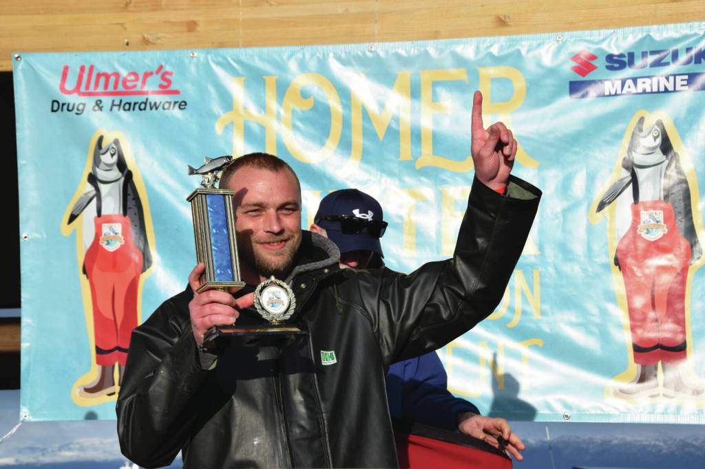 Tournament champion Zach Weimann holds up his first-place trophy during the 2025 Homer Winter King Salmon Tournament on Saturday. (Delcenia Cosman/Homer News)