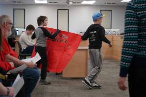 Students of Sterling Elementary School carry a sign in support of their school during a special meeting of the Kenai Peninsula Borough School District Board of Education in Soldotna, Alaska, on Wednesday, April 23, 2025. (Jake Dye/Peninsula Clarion)