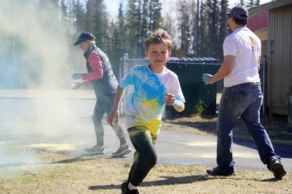 Students are covered in brightly hued powder during a color run at Kaleidoscope School of Arts and Science in Kenai, Alaska, on Saturday, May 3, 2025. (Jake Dye/Peninsula Clarion)
