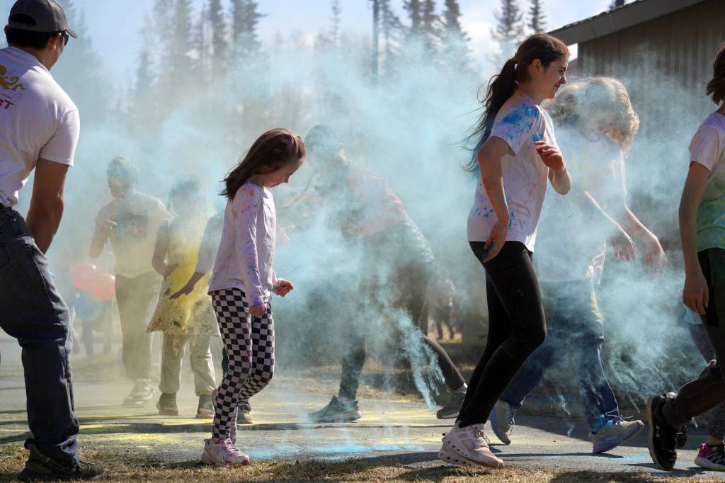 Students are covered in brightly hued powder during a color run at Kaleidoscope School of Arts and Science in Kenai, Alaska, on Saturday, May 3, 2025. (Jake Dye/Peninsula Clarion)