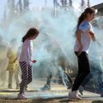 Students are covered in brightly hued powder during a color run at Kaleidoscope School of Arts and Science in Kenai, Alaska, on Saturday, May 3, 2025. (Jake Dye/Peninsula Clarion)