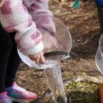 Students stock rainbow trout into Johnson Lake during Salmon Celebration, hosted by the Alaska Department of Fish and Game near Kasilof, Alaska, on Wednesday, May 7, 2025. (Jake Dye/Peninsula Clarion)