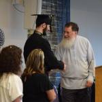 Fiofan Chernishoff (center) shakes Voznesenka School principal Michael Wojciaks hand as he is presented with his diploma during the commencement ceremony held Monday, May 19, 2025, at Lands End Resort in Homer, Alaska. (Delcenia Cosman/Homer News)