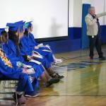 Kenai Alternative High School graduates listen to a speech by Principal John Galahan during their commencement ceremony in the schools gym in Kenai, Alaska, on Wednesday, May 22, 2025. (Jake Dye/Peninsula Clarion)