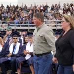 The parents of Tucker Challans, a Soldotna High School student who died in March, advance to receive an honorary diploma for their son on the schools football field in Soldotna, Alaska, on Wednesday, May 21, 2025. (Jake Dye/Peninsula Clarion)