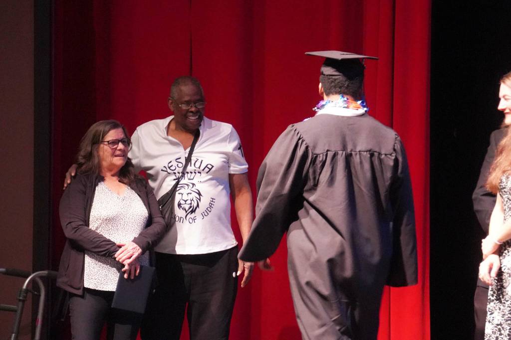Elijah Lee walks to receive his diploma from his parents during a graduation ceremony for Connections Homeschool in Soldotna, Alaska, on Thursday, May 22, 2025. (Jake Dye/Peninsula Clarion)