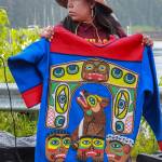 Apprentice carver Cheyanne Jack holds the mountain dog tunic at the ceremony on Friday, May 30, 2025. (Jasz Garrett / Juneau Empire)