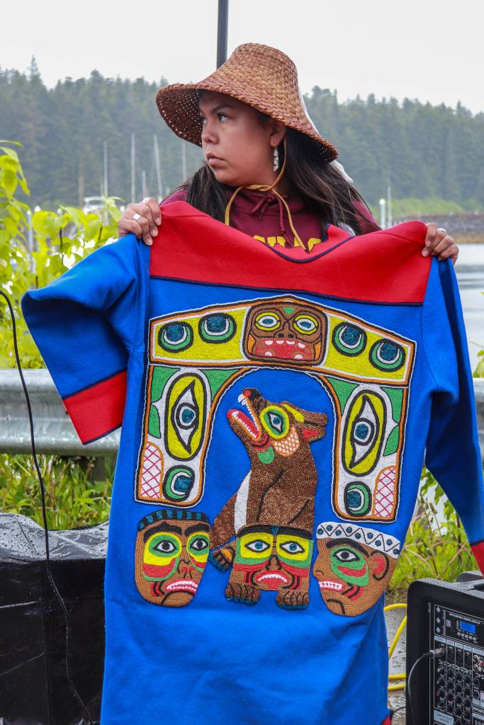 Apprentice carver Cheyanne Jack holds the mountain dog tunic at the ceremony on Friday, May 30, 2025. (Jasz Garrett / Juneau Empire)