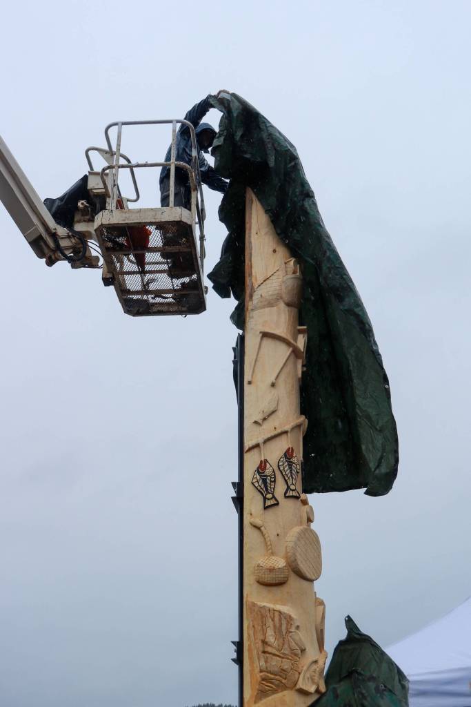 The 21-foot yellow cedar Fishermans Honor Totem Pole is unveiled in Hoonah on Friday, May 30, 2025. (Jasz Garrett / Juneau Empire)