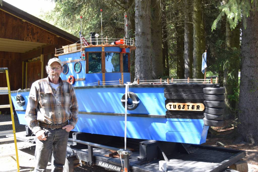 Larry Bernbeck poses for a photo with Tugster on Thursday, June 5, 2025 in Homer, Alaska. (Chloe Pleznac/Homer News)
