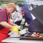 Teague Vanek grills up salmon during the 2025 Industry Appreciation Day at the Kenai Softball Greenstrip in Kenai, Alaska, on Saturday, Aug. 23, 2025. (Jake Dye/Peninsula Clarion)