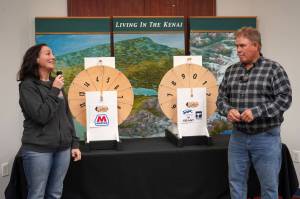 Kenai Chamber of Commerce Executive Director Samantha Springer and Kenai Mayor Brian Gabriel prepare to spin the wheels and determine the magic weight on the first day of the Ninth Annual Kenai Silver Salmon Derby at the Kenai Chamber of Commerce in Kenai, Alaska, on Tuesday, Sept. 9, 2025. (Jake Dye/Peninsula Clarion)