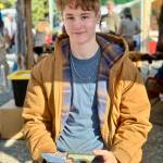 Jaxon Bourne holds one of his handmade knives at the Homer Farmers Market on Saturday, Sept. 13, 2025, in Homer, Alaska. Photo by Christina Whiting