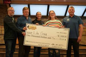 Lily Craig, second from right and youth winner of the Ninth Annual Kenai Silver Salmon Derby, stands with officials from the City of Kenai, Kenai Chamber of Commerce and Marathon Petroleum as shes awarded a novelty check for $1,000 at Kenai City Hall in Kenai, Alaska, on Wednesday, Sept. 17, 2025. (Jake Dye/Peninsula Clarion)