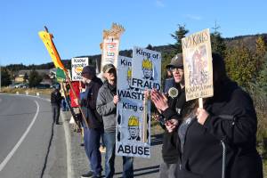 Protesters gather along the Sterling Highway and hold up signs during the No Kings demonstration on Saturday, Oct. 18, 2025, in Homer, Alaska. (Delcenia Cosman/Homer News)