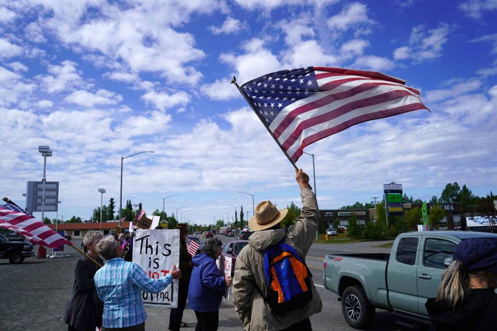 People carrying flags and signs line the Sterling Highway for a "No Kings" protest in Soldotna, Alaska, on Saturday, June 14, 2025. (Jake Dye/Peninsula Clarion)