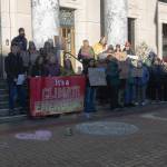 Dozens of Juneauites gather on the steps of the Alaska State Capitol building on Jan. 24, 2026 to participate in an anti-LNG pipeline protest led by the Juneau-Douglas High School: Yadaa.at Kalé chapter of Alaska Youth for Environmental Action. (Chloe Anderson / Juneau Empire)