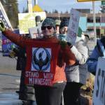 Jan Krehel waves at cars passing by as she holds a "Stand With Minnesota" banner during the "ICE OUT" demonstration on Sunday, Feb. 1, 2026, at WKFL Park in Homer, Alaska. (Delcenia Cosman/Homer News)
