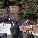 Community members carry signs protesting ongoing immigration raids and declaring solidarity with Minneapolis during the ICE OUT demonstration on Sunday, Feb. 1, 2026, at WKFL Park in Homer, Alaska. (Delcenia Cosman/Homer News)